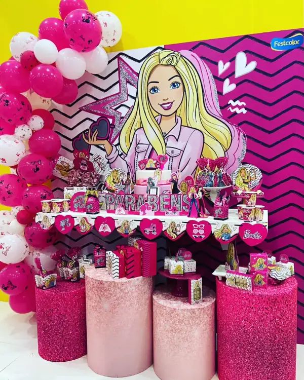 Mesa de festa montada com tema de boneca, com painel, balões e lembrancinhas